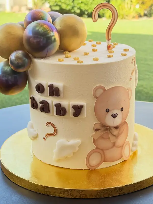 Torta beige «Oh baby» con osito, esferas doradas y chocolate